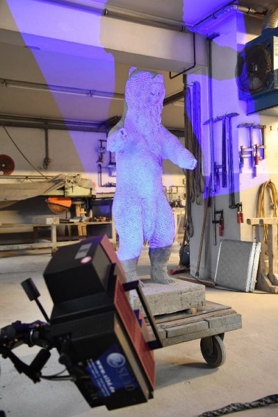 Während auf der Oberfläche des Berliner Bären Messmarken befestigt waren, wurde die in blaues Licht gehüllte Skulptur mit einer Speziallinse Millimeter für Millimeter abgetastet. Foto: Arnold